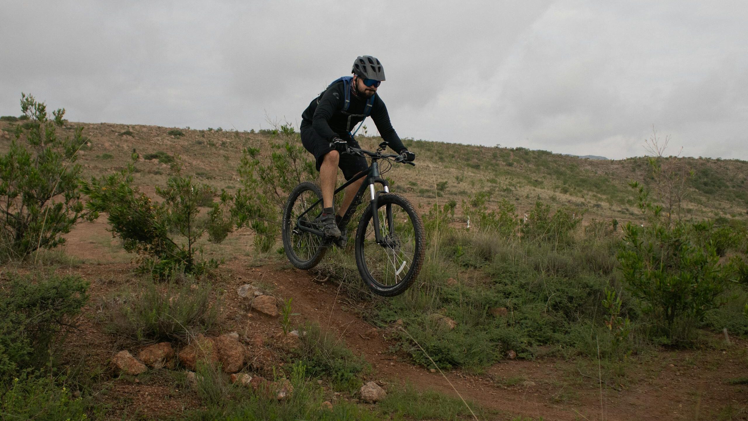 Cyclist riding a mountain bike on a trail in San Luis Potosí, Mexico's scenic landscape.